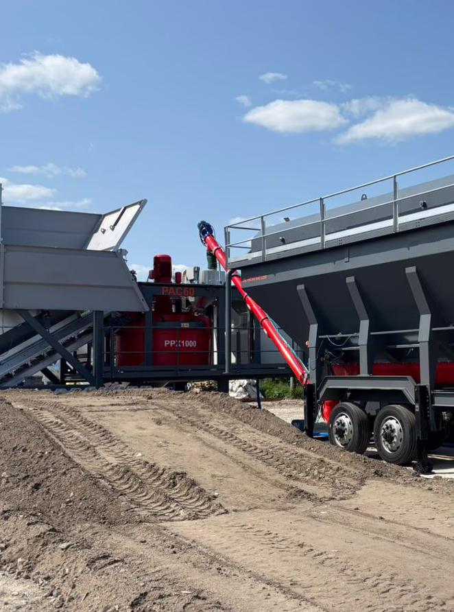Compact concrete batching plant with integrated aggregate hoppers and twin-shaft mixer system on a trailer chassis
