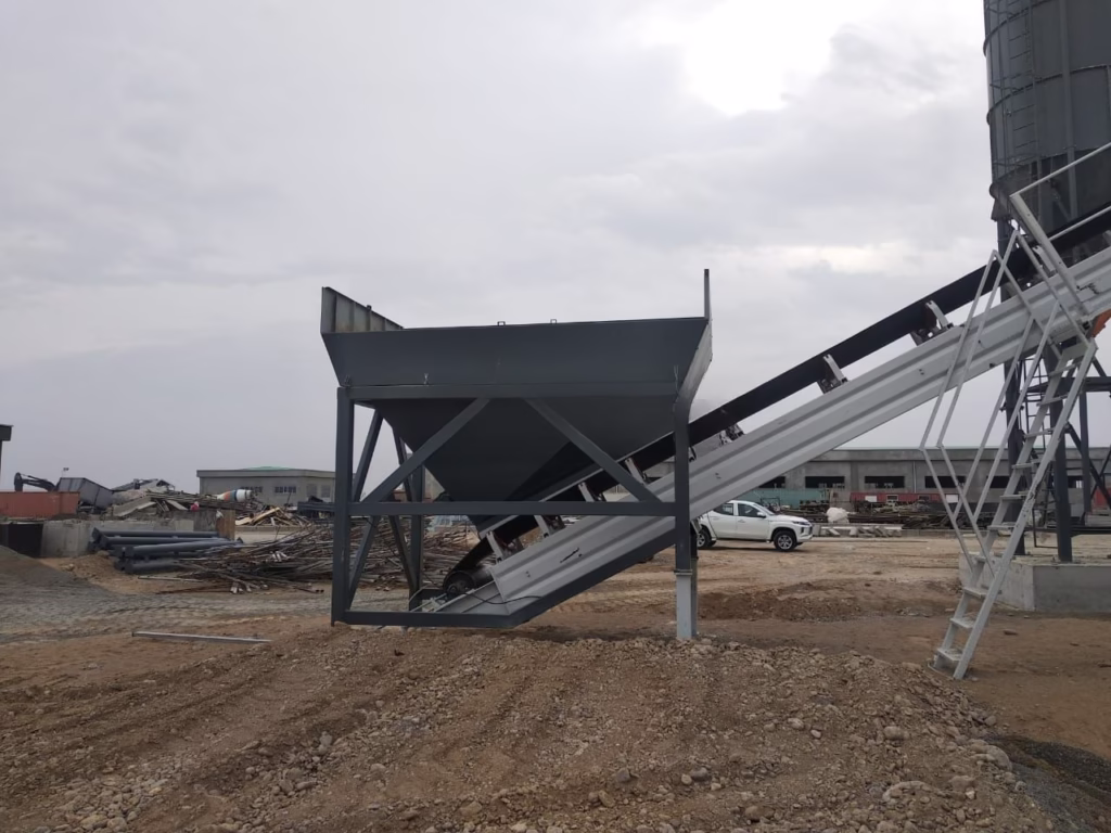 Polygonmach aggregate feeding hopper connected to conveyor belt for continuous material handling